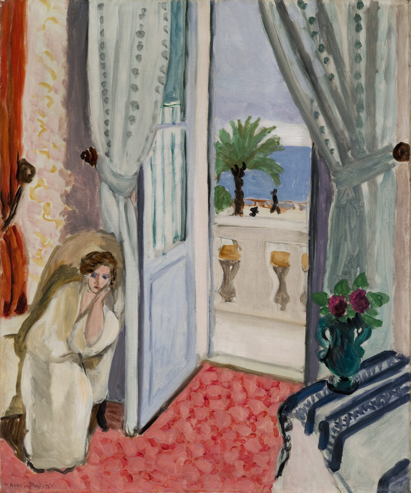 Fauvist oil painting Interior at Nice by Henri Matisse, featuring a woman seated by an open balcony door with sea views, patterned curtains, a pink floral carpet, and a vase of flowers.