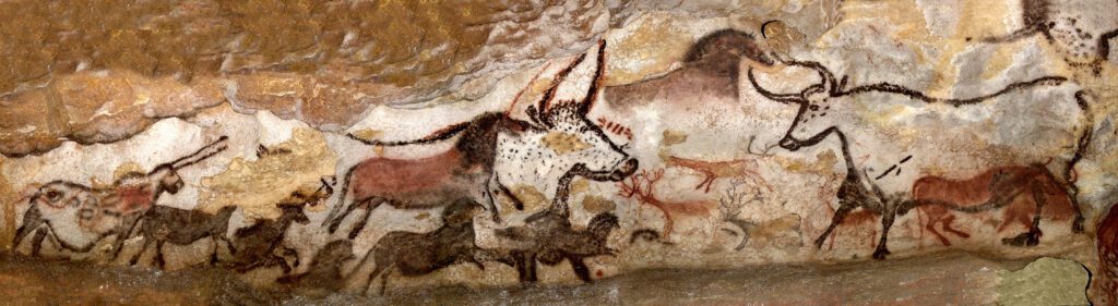 Prehistoric cave painting from the Great Hall of the Bulls in Lascaux depicting aurochs, wild horses, and deer running across the stone wall.